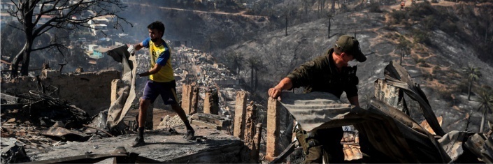 Two men moving debris following the Chile wildfires swept through