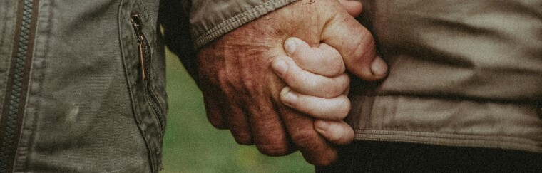 Two elderly hands holding each other